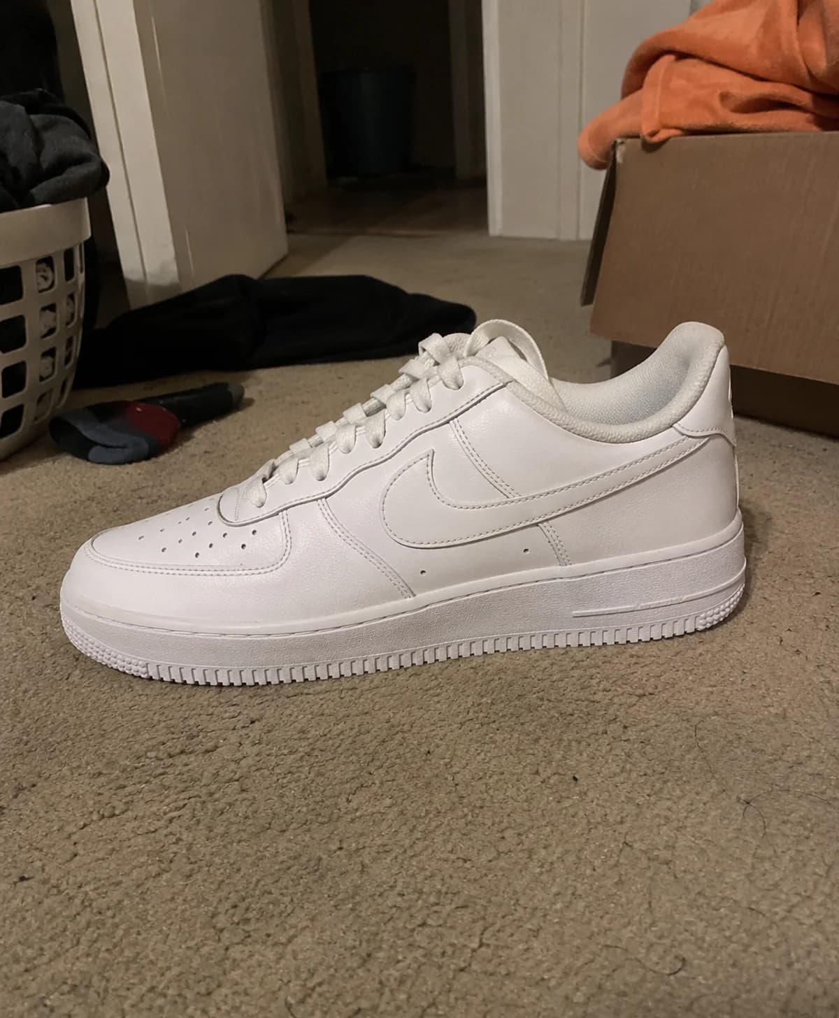 Schlechtes Verkaufsfoto eines weißen Sneakers mit unruhigem Hintergrund
